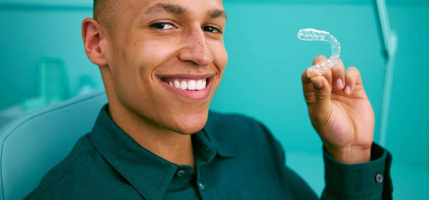 Femme souriant tenant un aligneur DR SMILE en main