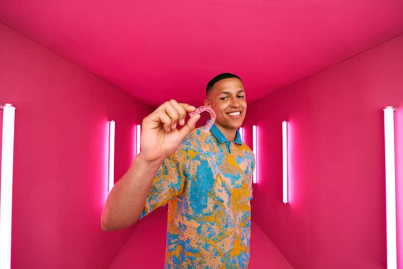 [CRO] Man - Aligner - In front - Hand - Look to the aligners - Pink - Light - Background - Desktop