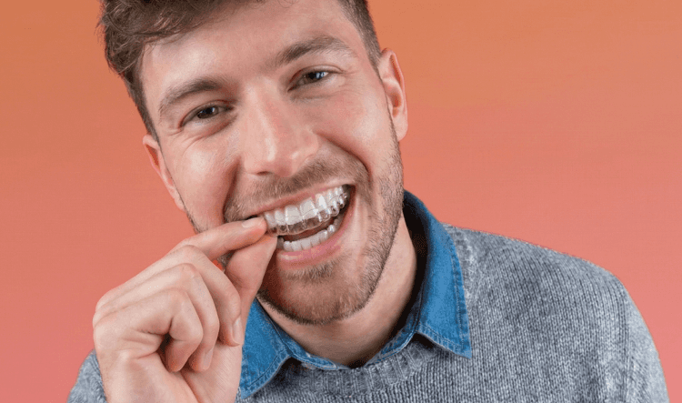 [CRO] Man - Aligner - In front - Hand - Look to the aligners - Pink - Light - Background - Desktop